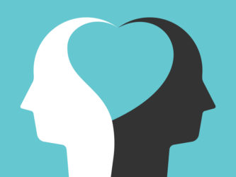 Two white and black head silhouettes united by heart shape inside them on turquoise blue. Unity, peace, love concept. 