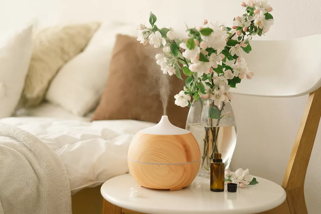 Aromatherapy Concept. Aroma oil diffuser on chair against in the bedroom. Air freshener. Ultrasonic aroma diffuser for home
