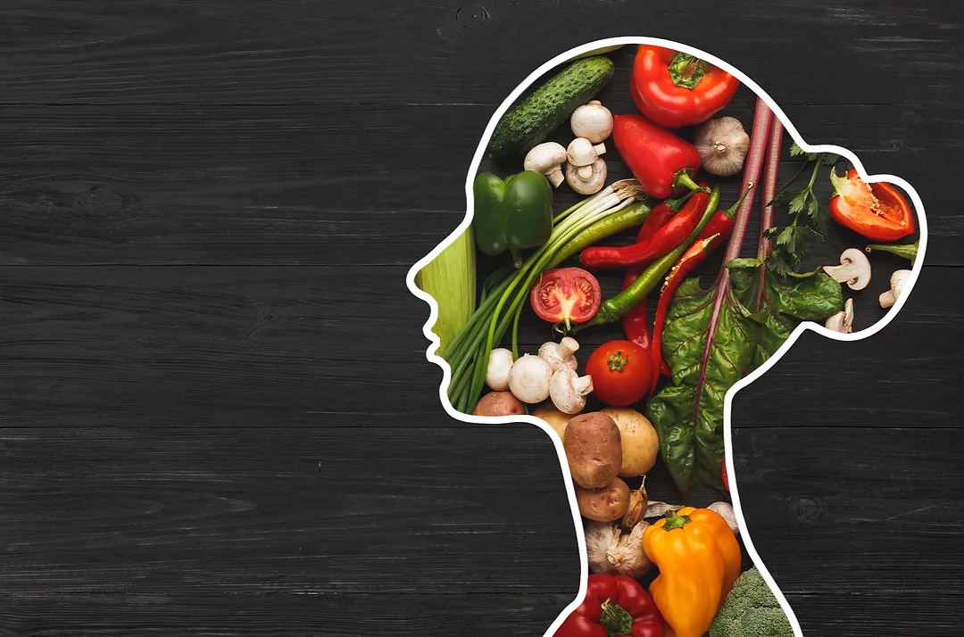 Food for health. Woman silhouette with fresh vegetables in her body on wooden background with copy space, panorama