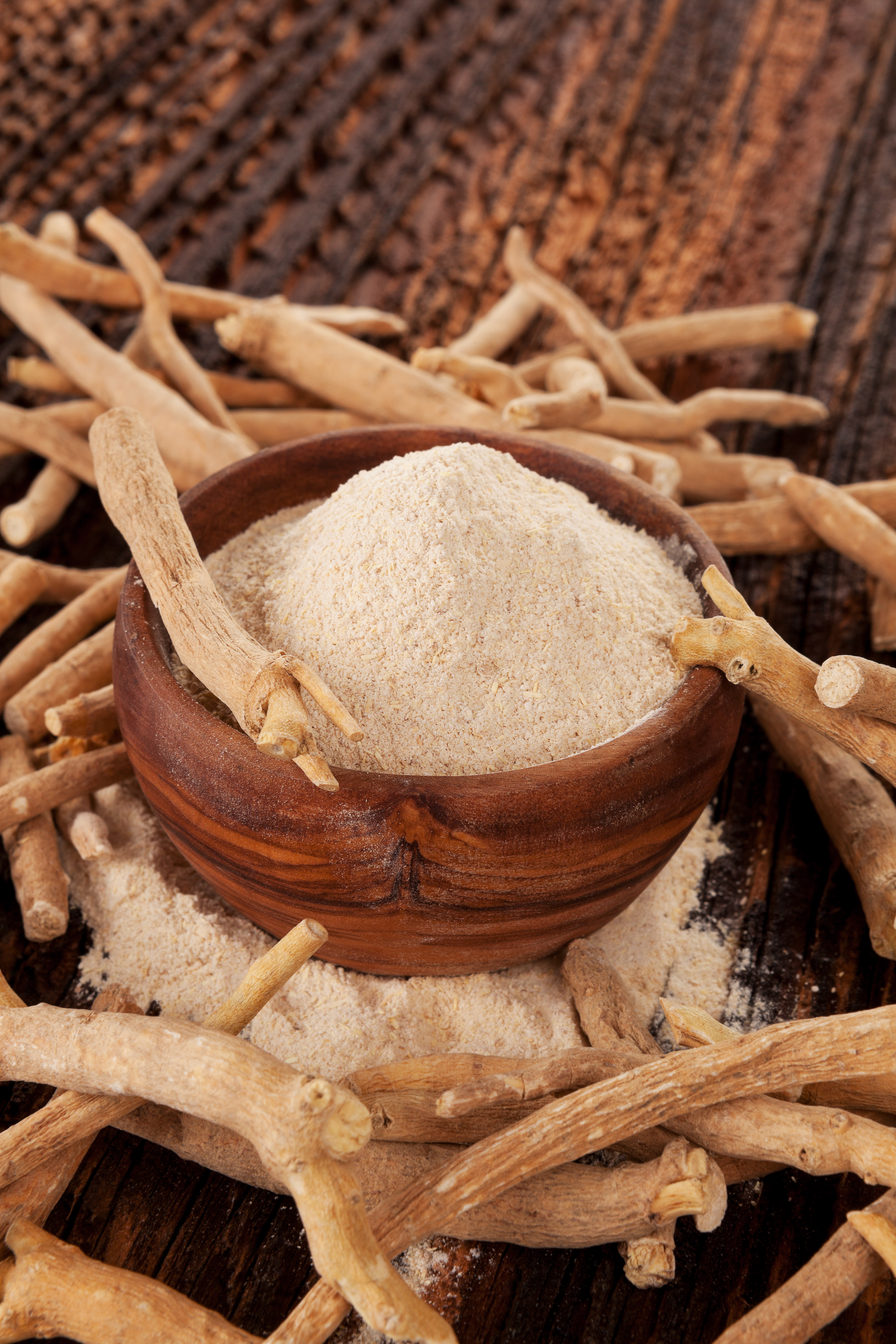Ashwagandha root extract alongside ashwagandha roots, representing new clinical research evaluating the safety of a 2,000 mg daily dose in healthy adults.