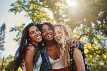 Portrait of three diverse young women ethnic friends having fun