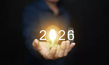 2026 New Year business goals: A businessman holds an illuminated lightbulb and '2026,' symbolizing new ideas, success, solutions, insights, and innovation.