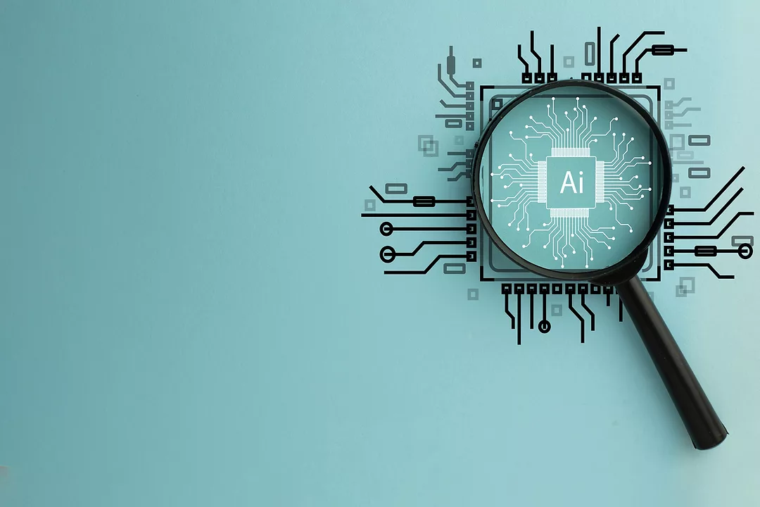 Magnifying Glass Focused on Circuit Board with AI Word, Representing Artificial Intelligence and Technology Innovation.