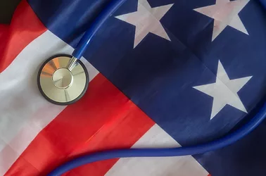 A stethoscope on an American flag symbolizing healthcare in the USA.