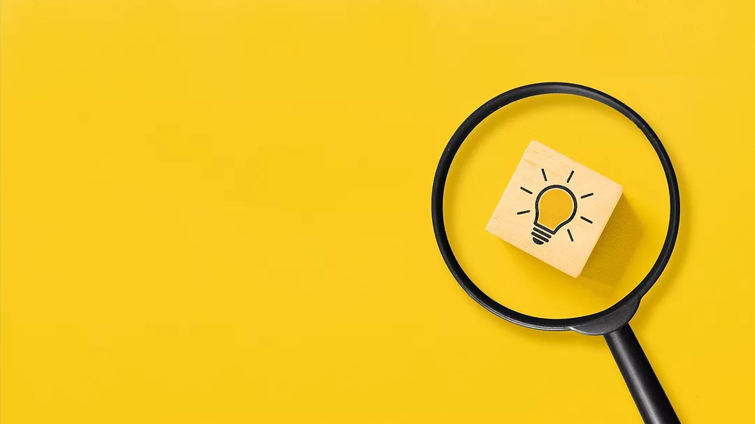 Creative idea concept, magnifying glass and light bulb icon on wooden block with yellow background