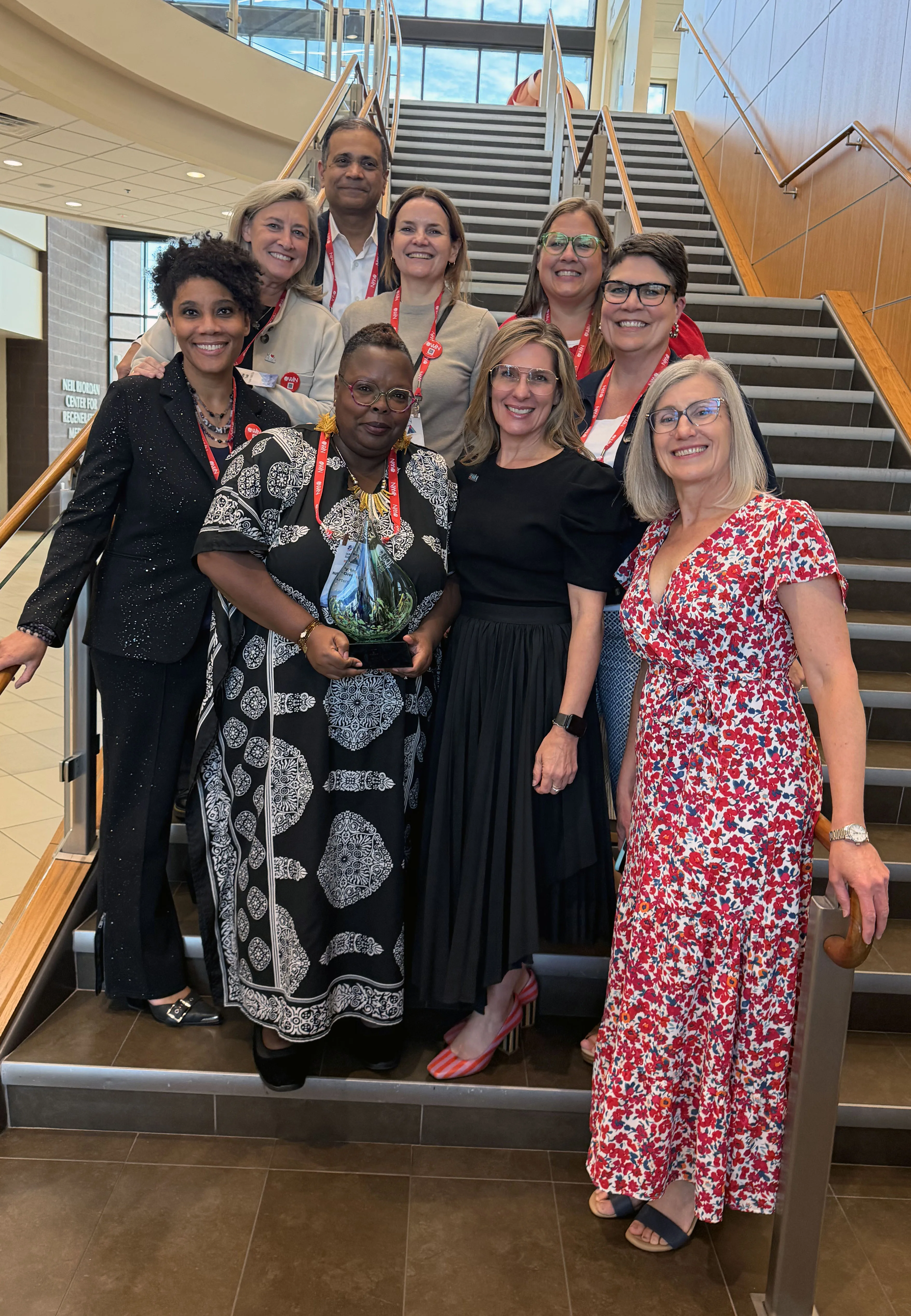 Mary Ann Nation-Greenwall encircled by WIN members, holding 2026 WIN Heroine Award.