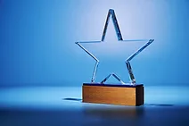 Award-Winner-GettyImages-2255269239.jpg Crystal star shape trophy against blue background